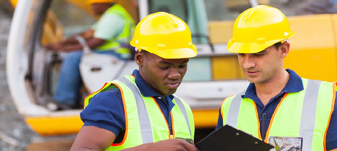 Two workers in hard hats consulting clipboard